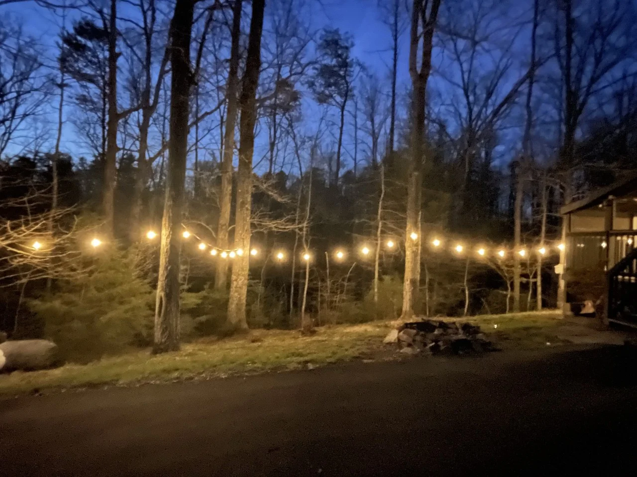 Backyard patio with string lights and fire pit at Pigeon Forge cabin for families
