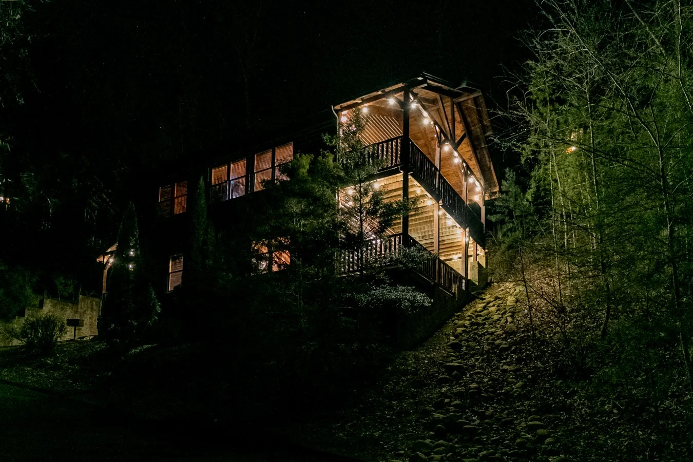 Smoky Mountain Escape cabin lit at night, a cozy base for rainy day activities Gatlinburg guests plan