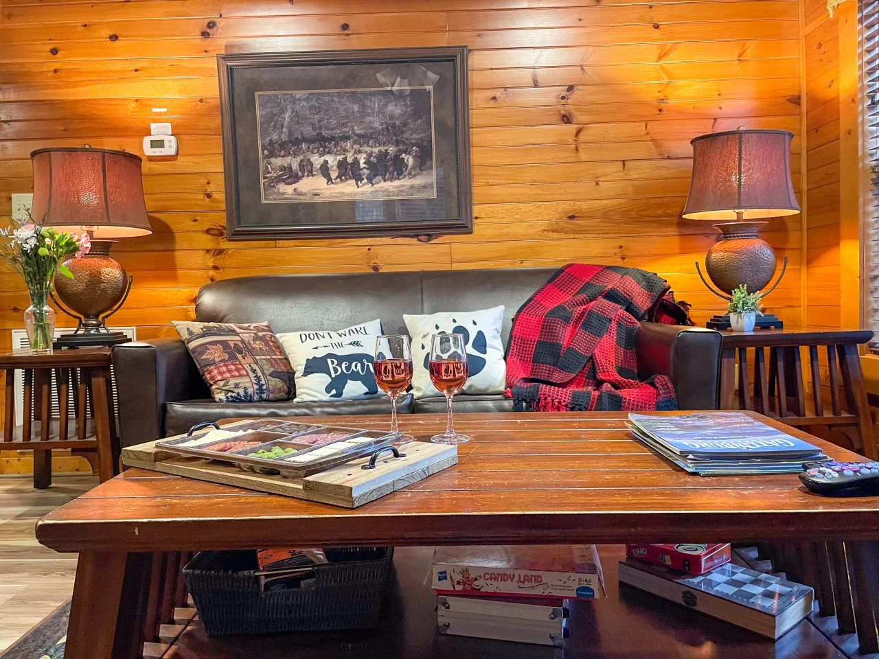 Cozy log cabin living room with leather sofa and bear-themed pillows in Gatlinburg TN vacation rental