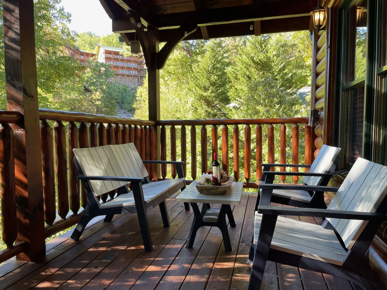 Covered patio with Adirondack chairs and forest valley views at Bear Crest Cabins in Gatlinburg