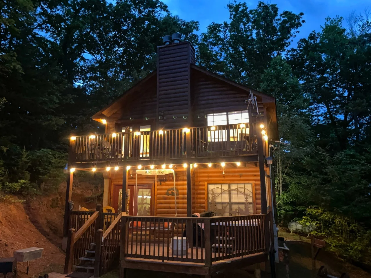 Pet friendly log cabin exterior with wraparound deck and stone chimney in Sevierville TN