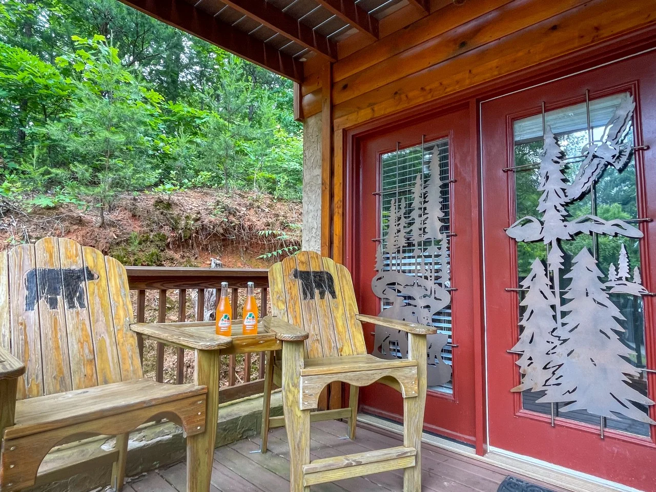 Rustic wooden Adirondack chairs with bear silhouettes on a cabin patio with forest views, near Sevierville, TN at Bear Crest