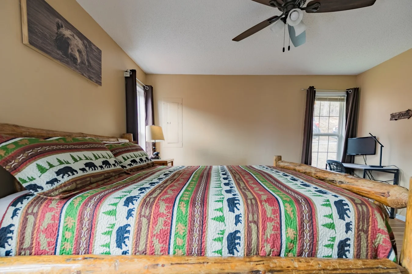 Rustic log bed with wildlife bedding in cozy Gatlinburg TN cabin bedroom with mountain lodge decor