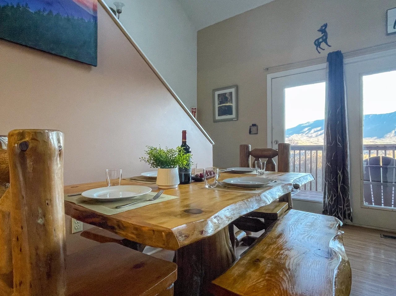 Rustic dining room with live-edge wood table, mountain views through glass doors at Gatlinburg cabin