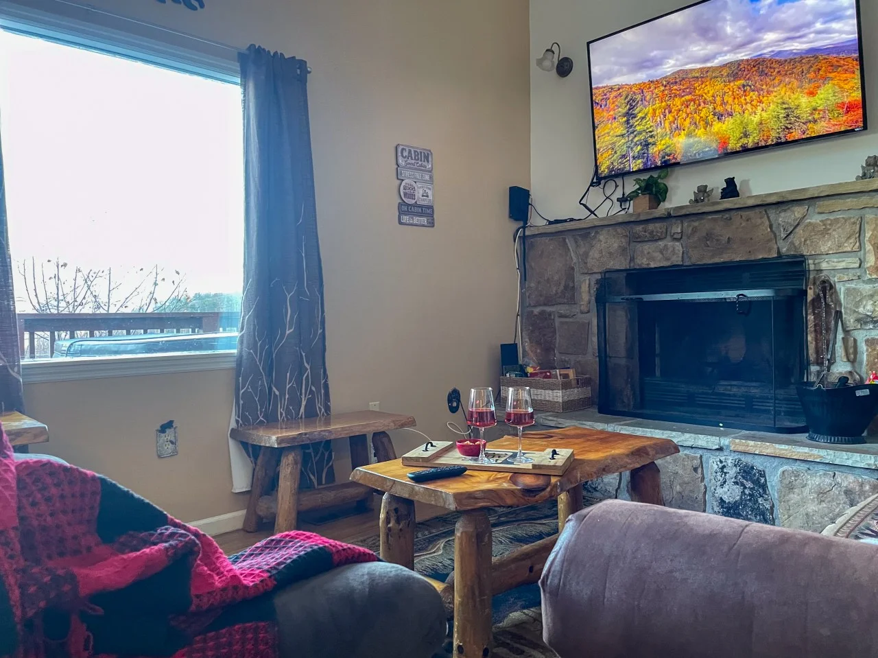Cabin living room with stone fireplace and mountain views, a cozy end to date night ideas Gatlinburg couples enjoy