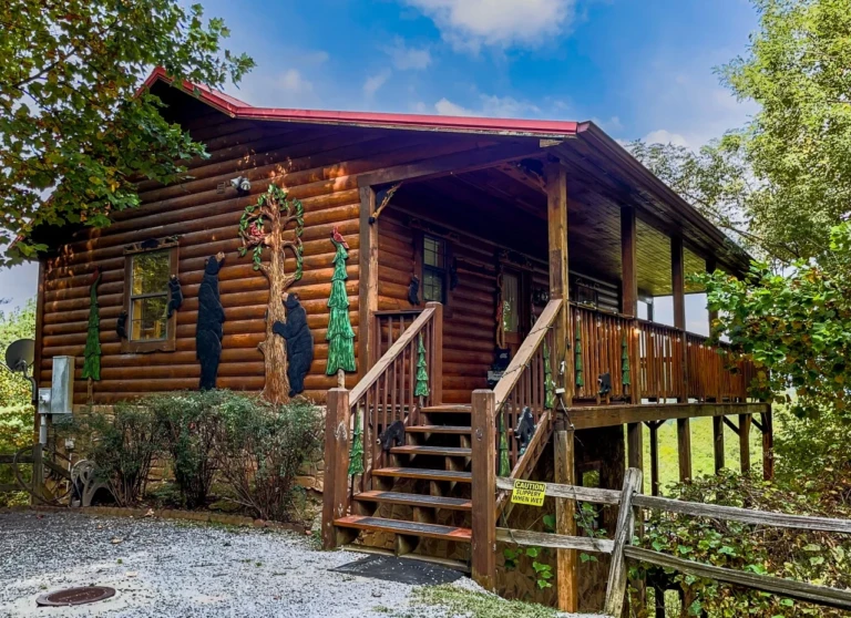 Rustic log cabin with bear cutouts and red roof, a book direct cabin Gatlinburg area pick