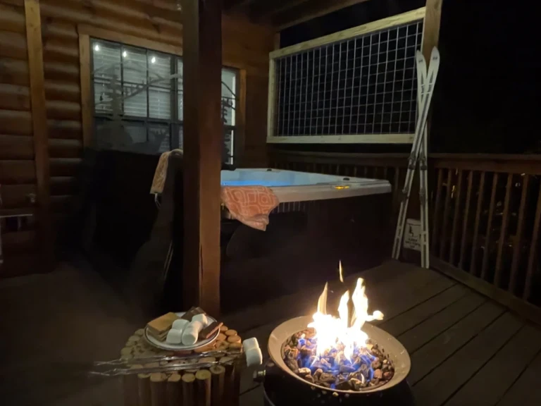 Hot tub and lit fire pit with mountain views at night, a cabin setting for Gatlinburg couples
