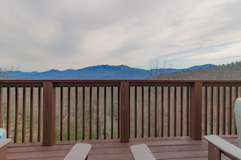 Wooden deck with Adirondack chairs overlooking panoramic blue ridge mountains at Heavenly View vacation rental